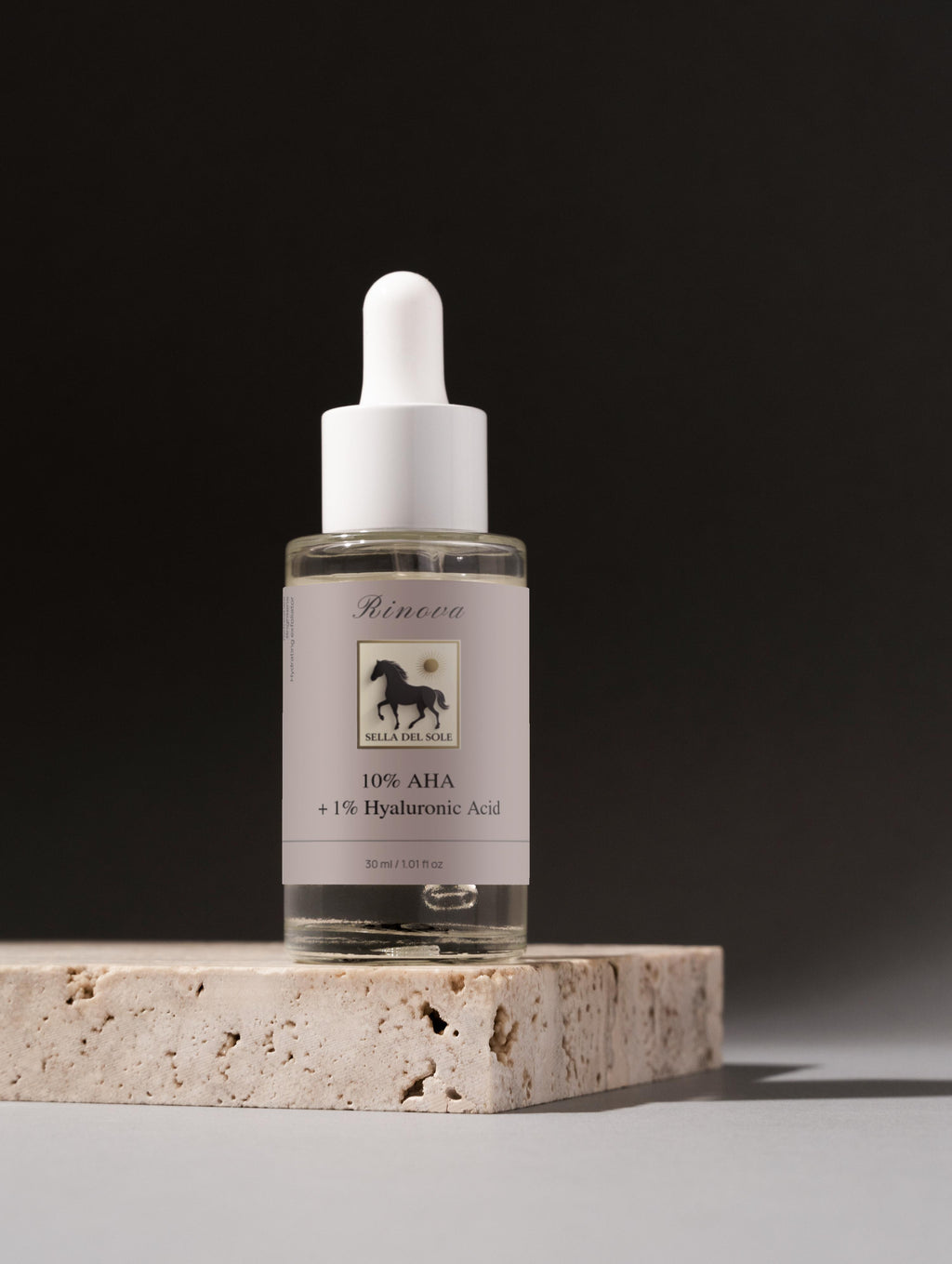 Rinova AHA bottle with dropper on a stone surface against a dark background